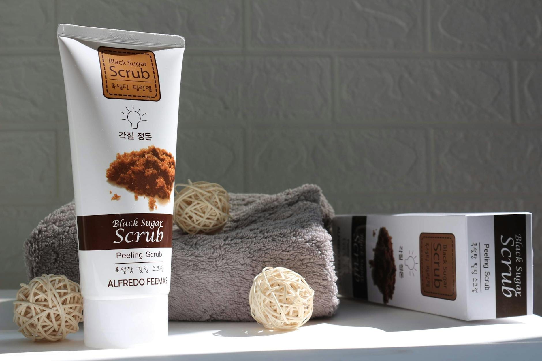 Czarna tubka peelingu cukrowego na ręczniku do domowej pielęgnacji skóry