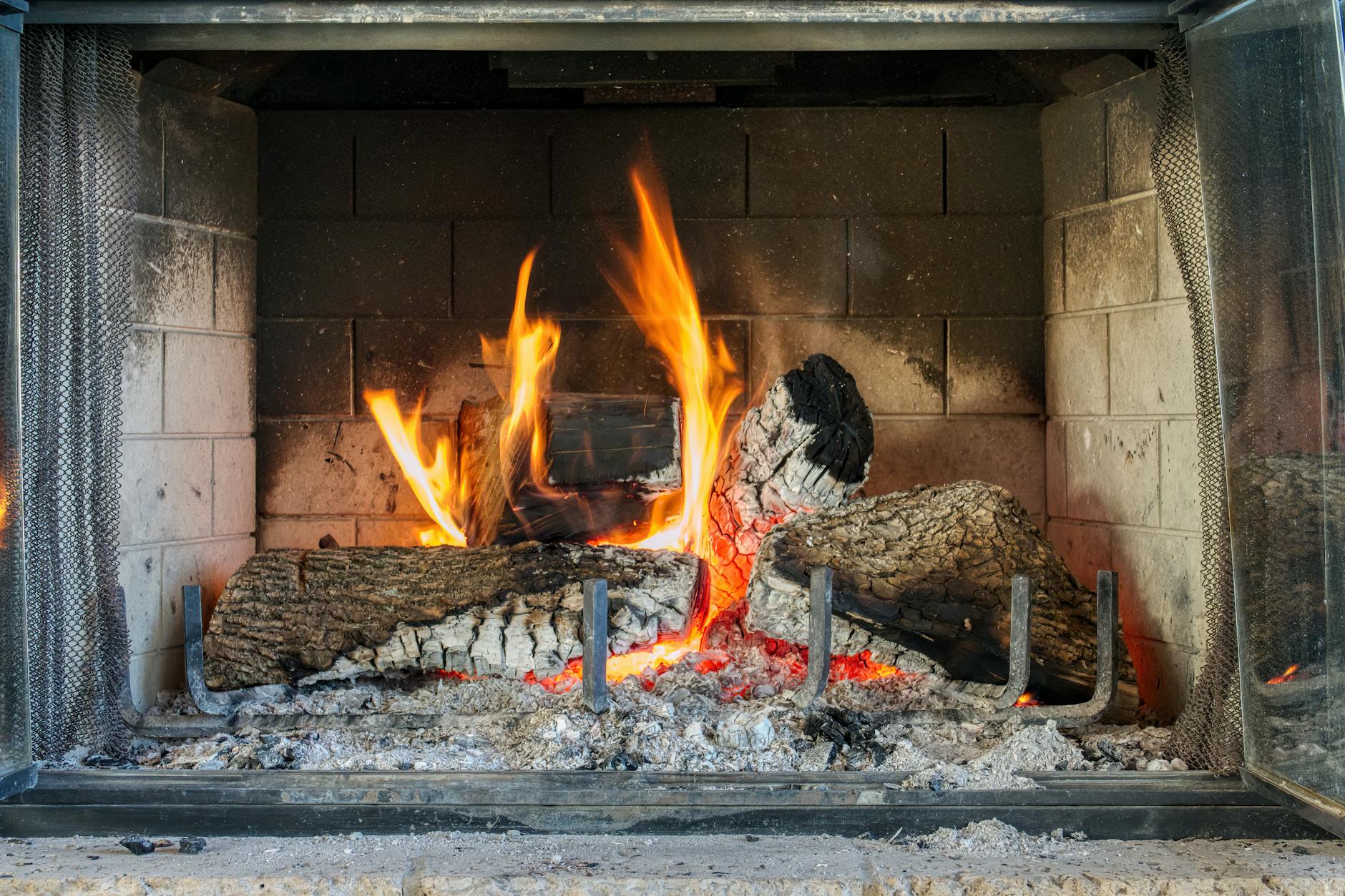 Płonące polana w przytulnym kominku w salonie