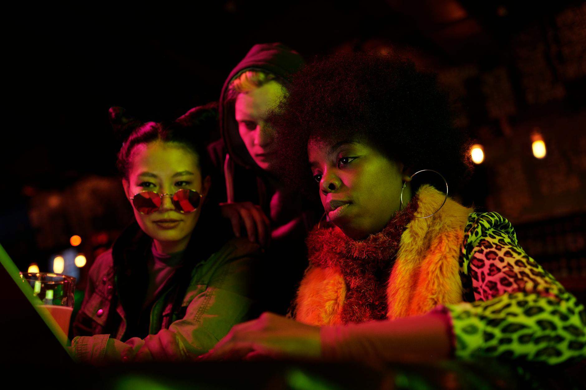 Trzy osoby przy laptopie w klubie, planują wyjście na fitness po pracy