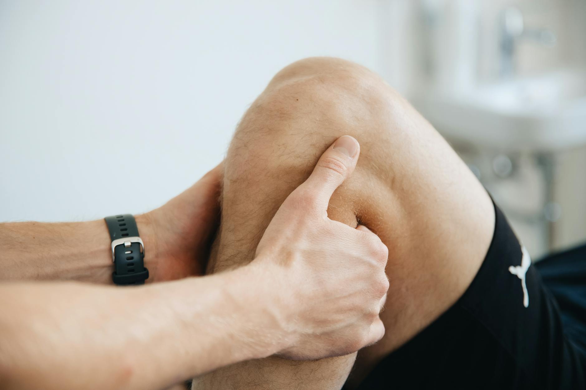 Fizjoterapeuta wykonuje masaż kolana pacjenta po operacji