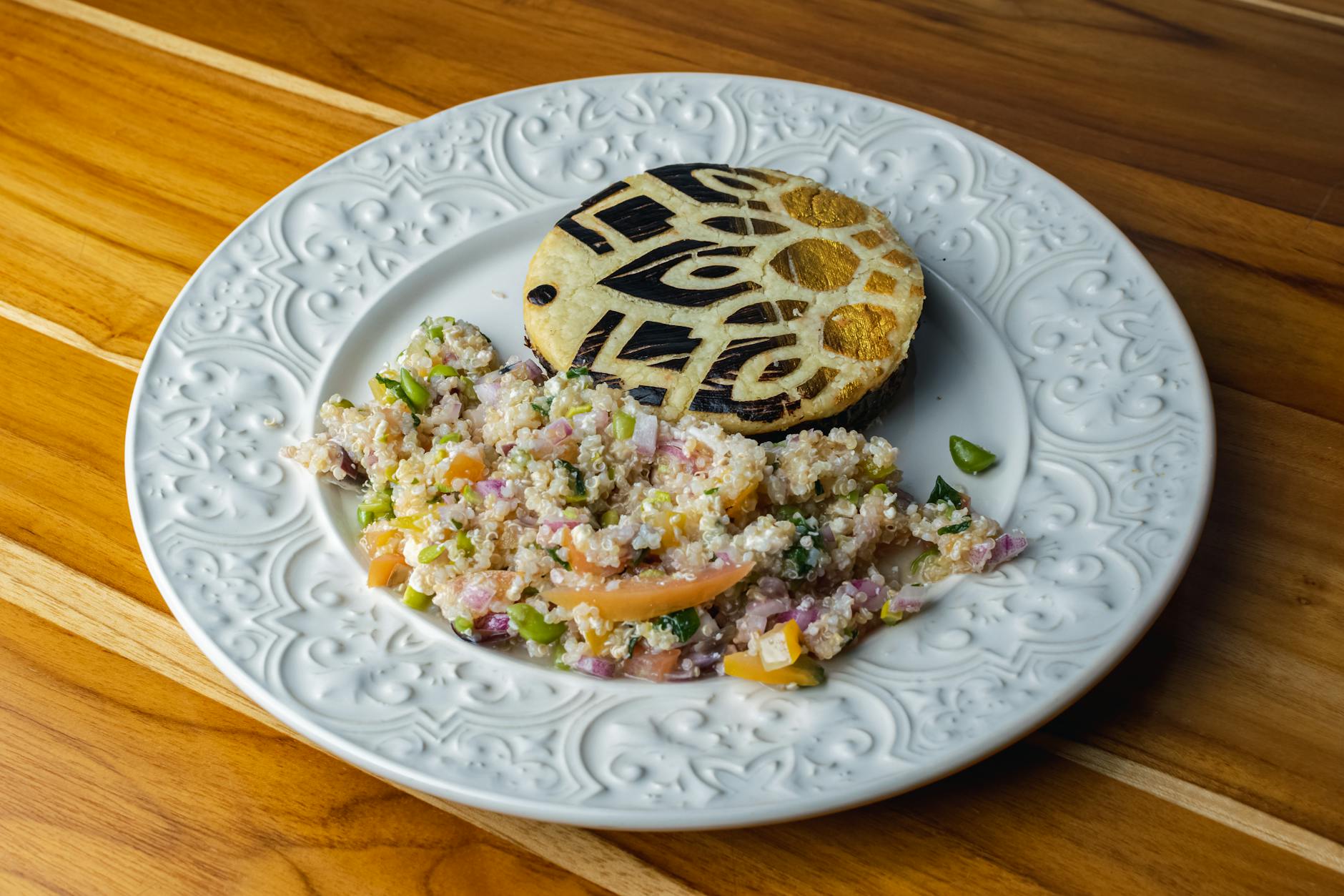 Kolorowa sałatka z komosą ryżową i kromką chleba na ozdobnym talerzu