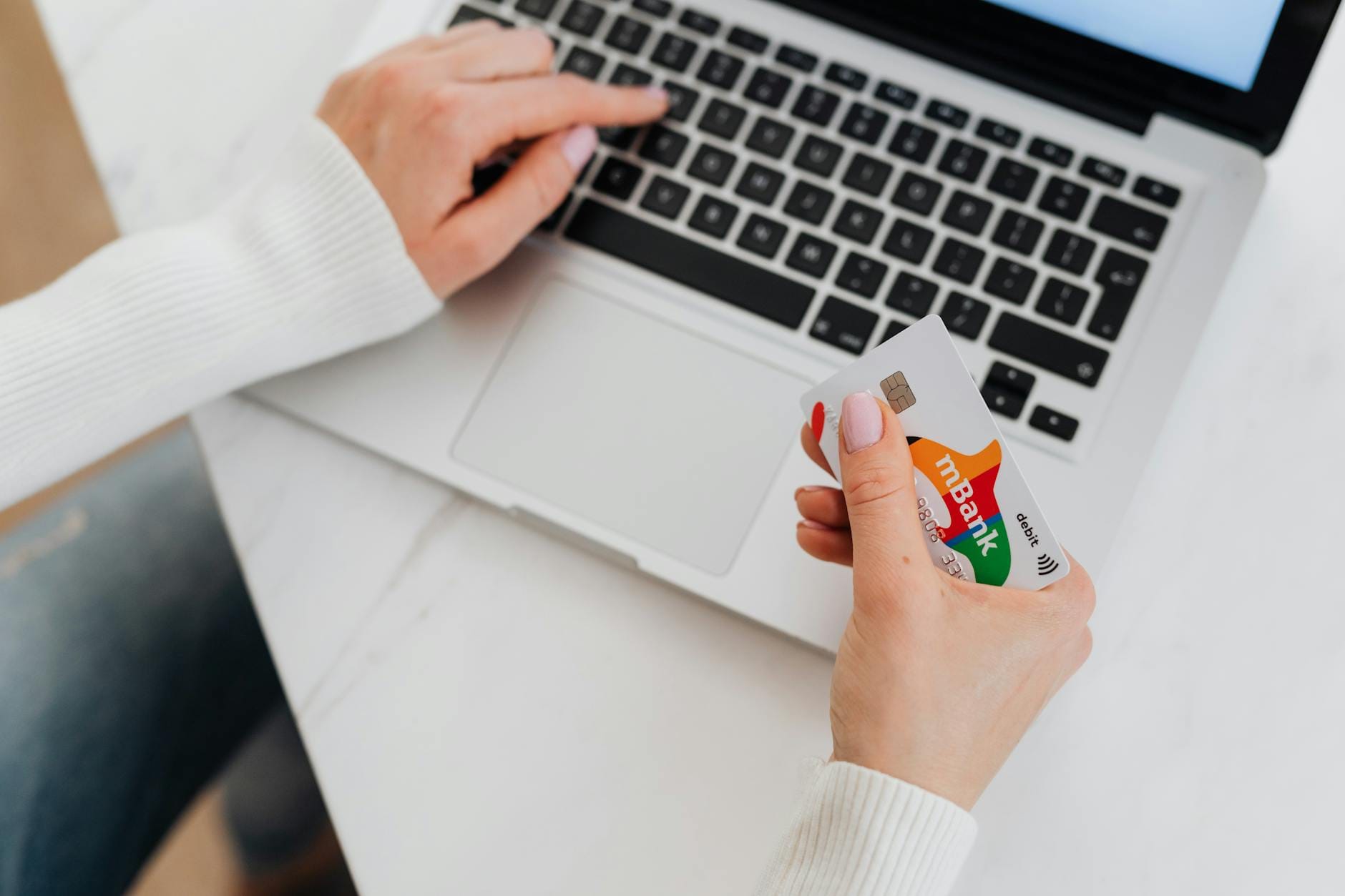 Osoba z kartą kredytową płacąca online przy laptopie