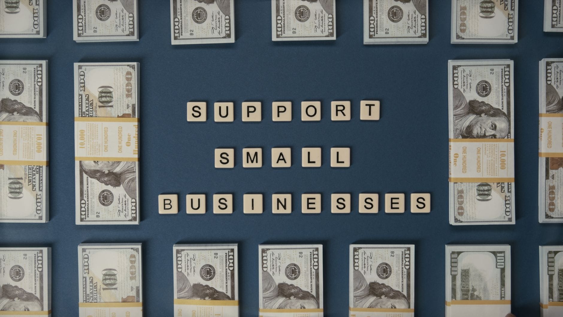 Banknoty dolarowe z ułożonym napisem small business z kostek liter