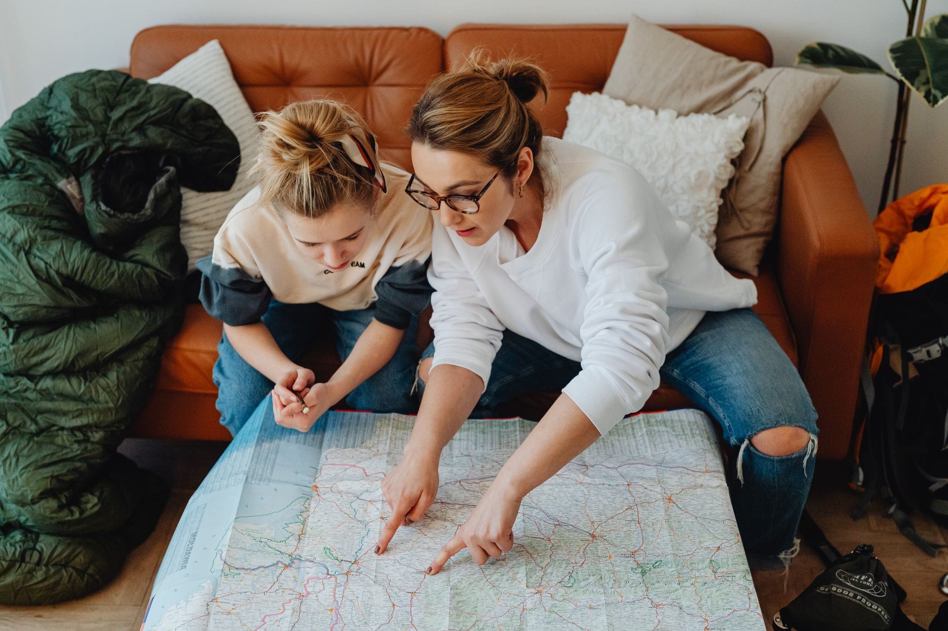 Mama z córką planują rodzinny weekend na mapie w salonie Mama z córką planują rodzinny weekend na mapie w salonie