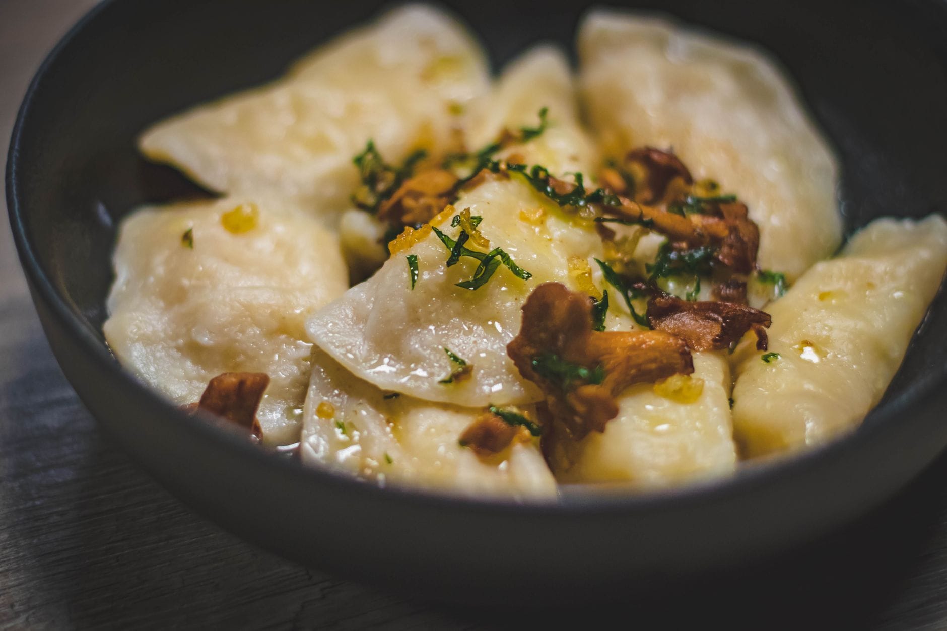Pierogi z kurkami i ziołami na eleganckim talerzu w restauracji