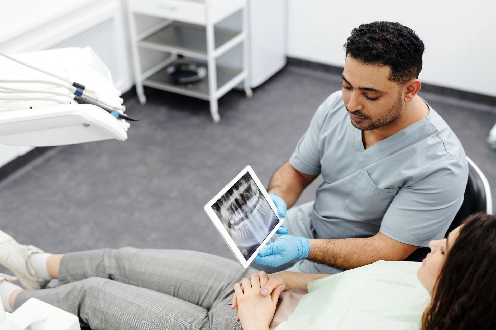 Dentysta pokazuje pacjentowi zdjęcie RTG zębów na tablecie