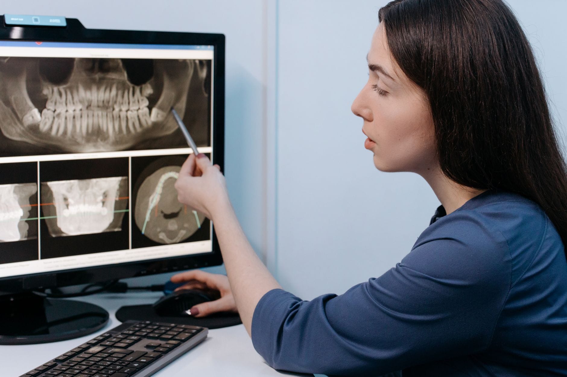 Dentystka analizuje zdjęcie RTG zębów na monitorze w gabinecie