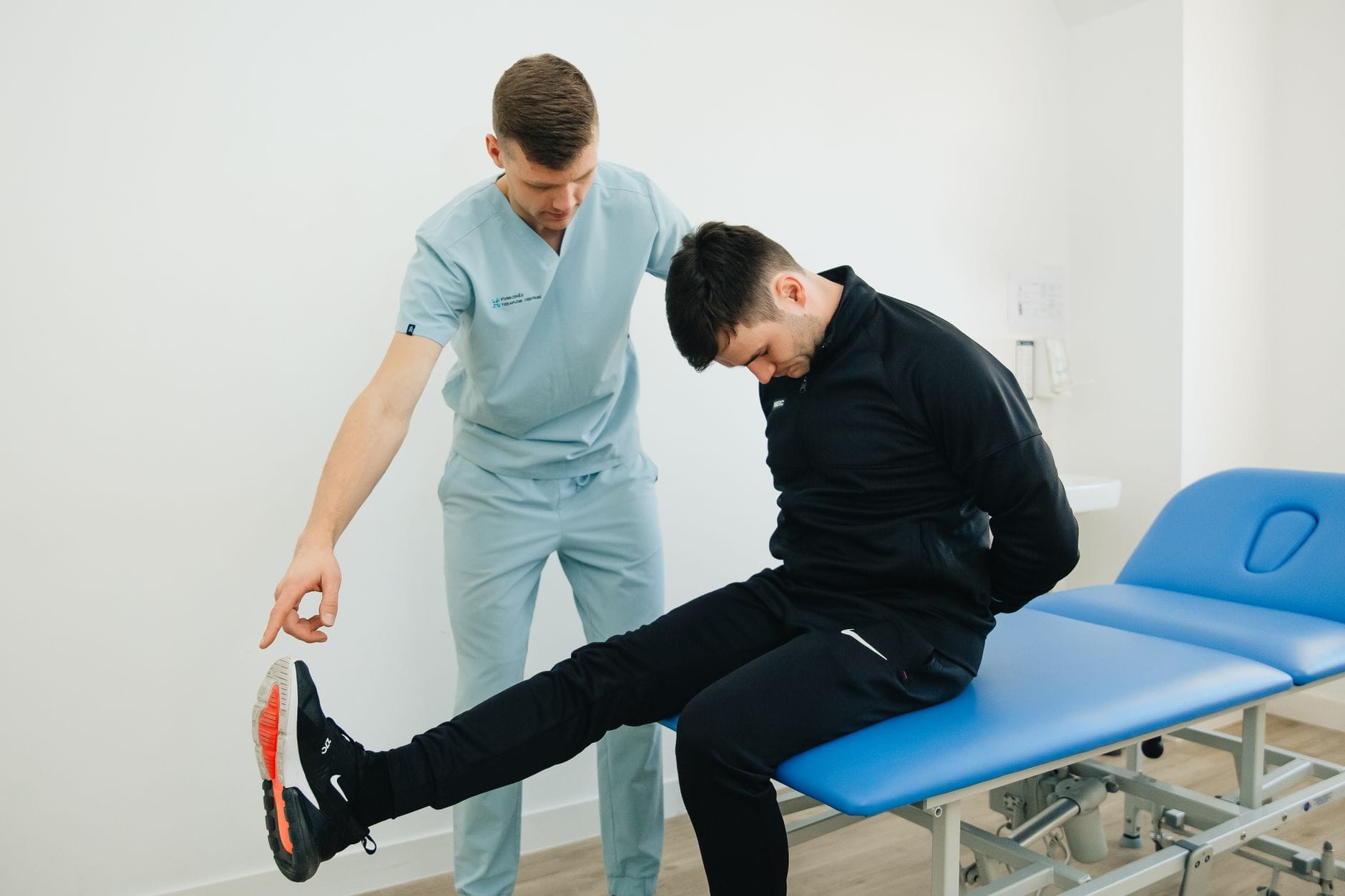 Fizjoterapeuta pokazuje pacjentowi ćwiczenia rehabilitacyjne w klinice